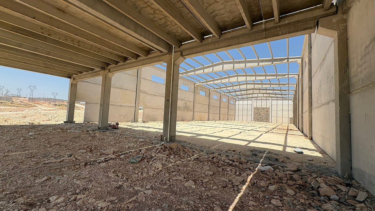 View from beneath the mezzanine slab into the main hall: beams, columns and panel walls.