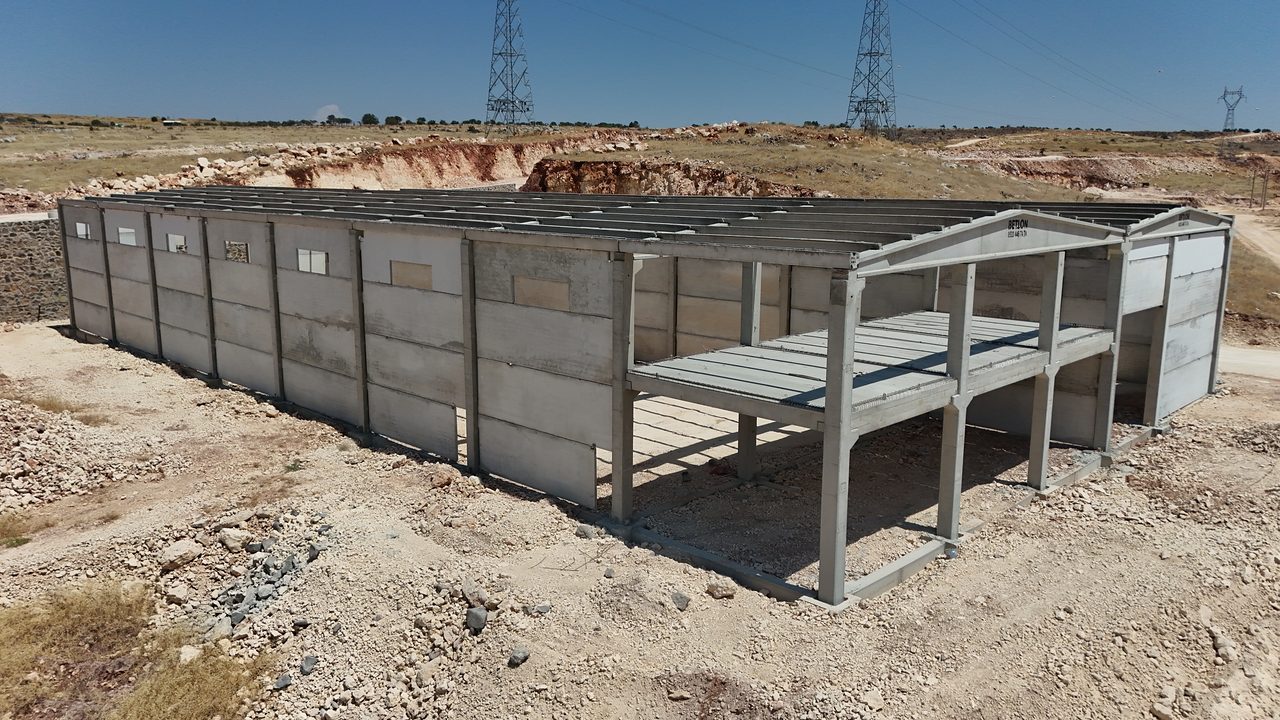 Precast wall panels along the long facade, with the mezzanine section at the corner.